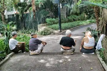 four persons sitting on gray surface