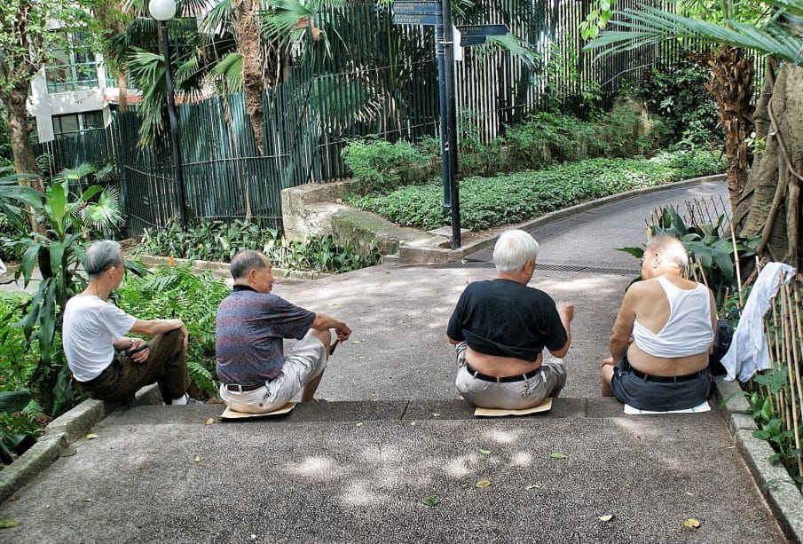 four persons sitting on gray surface
